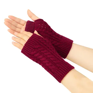 Close-up of burgundy cable knit fingerless gloves showing intricate openwork details.