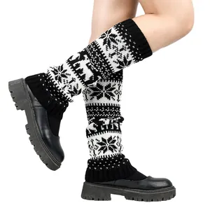 Detailed macro view of knitted Christmas leg warmers featuring snowflake and deer motifs