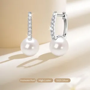 Detail van S925 zilveren oorringen met moissanite en zoetwaterparels.
