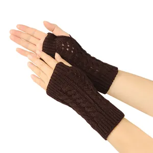Detailed macro view of brown cable-knit fingerless gloves featuring hollow heart patterns