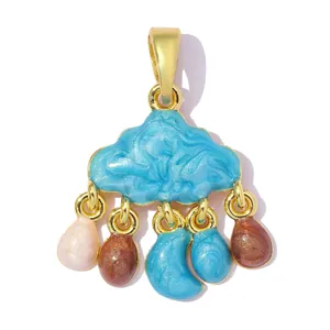 Détail macro d'un pendentif nuage en émail bleu avec des breloques et lunes colorées
