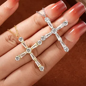 Gros plan de colliers en croix étincelants en or et argent avec moissanite