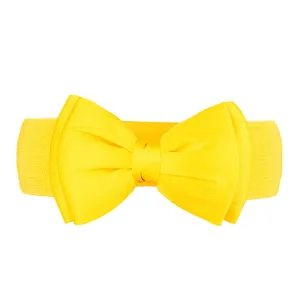 Detail view of a bright yellow elastic waist belt with a large decorative chiffon bow