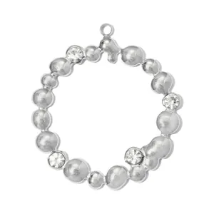 Detail view of a silver stainless steel circular pendant with clear crystal inlays