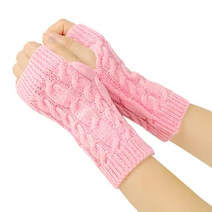 Macro view of pink cable knit fingerless gloves showing warm textured wool pattern