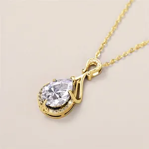 Dettaglio macro di una collana con pendente a goccia dorata con brillante pietra Moissanite