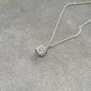 Close-up detail view of a minimalist 14k gold-filled moissanite solitaire pendant necklace
