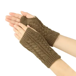 Close-up detail of brown cable knit fingerless gloves featuring a delicate hollow-out pattern.