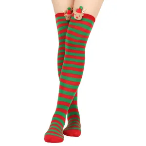 Detail of festive red and green striped Christmas thigh high socks with reindeer motifs