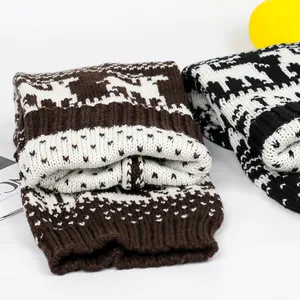 Detailed view of thick knitted leg warmers with festive reindeer and snowflake patterns.