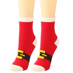 Detail shot of festive red Christmas socks with Santa belt design on mannequin legs.