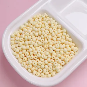 Gedetailleerde opname van 4 mm crèmekleurige matte glazen kralen in witte tray