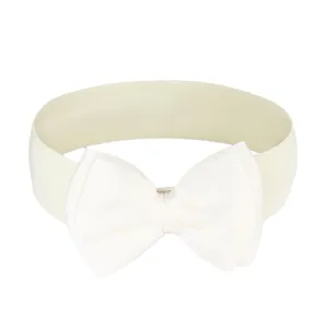 Detail view of a cream elastic belt featuring a large chiffon bow decoration.