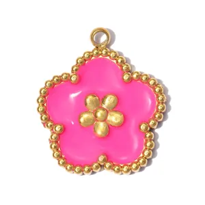 Close-up detail of pink enamel flower pendant with golden beaded edge and center blossom