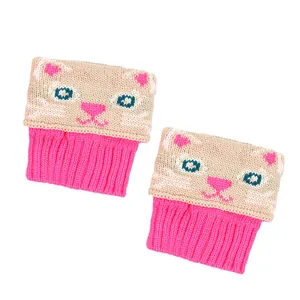 Gros plan du motif jacquard chat sur les jambières en tricot rose et beige pour femmes.