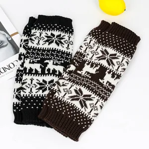Detailed texture of thick knitted Christmas leg warmers featuring snowflake and deer motifs