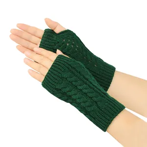Close-up of dark green cable knit fingerless gloves featuring hollow patterns for winter.