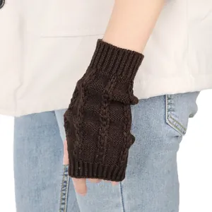 Nahaufnahme eines dunkelbraun gestrickten fingerlosen Handschuhs mit Zopfmuster