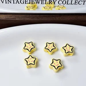 Perline a forma di stella gialla con faccina sorridente per gioielli fai da te su piatto