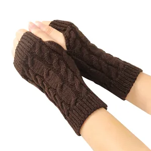 Close-up detail of brown cable knit fingerless gloves showing thick textured pattern