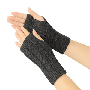 Close-up detail of dark grey cable knit fingerless gloves with hollow-out patterns
