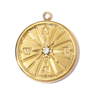 Detail view of a gold-plated stainless steel compass pendant with central crystal