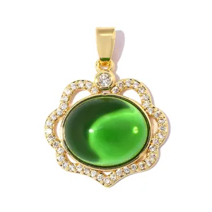 Detail view of the 18k gold plated cloud lock pendant with a vibrant green gemstone