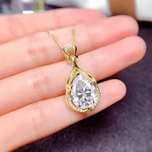 Dettaglio di un ciondolo a goccia dorato con una scintillante moissanite con taglio a pera.