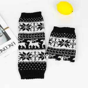 Detail showing knitted snowflake and deer patterns on black and white leg warmers