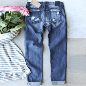 Detailed back view of distressed slim fit blue denim jeans with ripped pocket details.