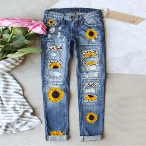 Close-up detail of women's slim fit jeans featuring sunflower and leopard print patches