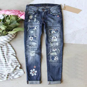 Close-up of slim-fit denim jeans with distressed floral and leopard print patchwork.