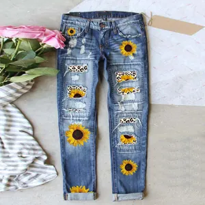 Close-up of sunflower patches and leopard print lining on distressed denim jeans.