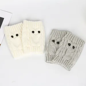 Close-up detail of soft knitted owl leg warmers in ivory white and light grey colors