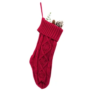 Grande chaussette de Noël en tricot rouge avec pommes de pin et verdure festive