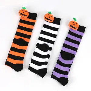 Detail view of colorful Halloween striped knee-high socks with cute pumpkin dolls.