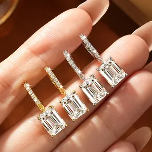 Detailed view of sparkling emerald cut moissanite earrings in gold and silver