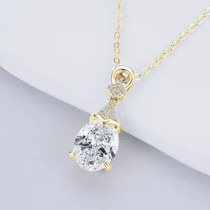 Primo piano di elegante collana in moissanite a goccia con catena dorata e dettagli.