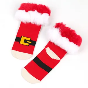 Detailed view of red Christmas socks with fluffy faux fur trim and Santa suit belt design