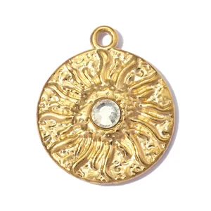 Close-up detail of a gold stainless steel sun relief pendant with a clear center gemstone