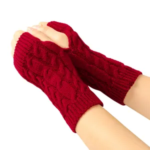 Close-up detail of red cable knit fingerless gloves showing intricate woven texture