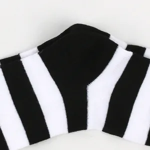 Close-up of black and white striped children's over-the-knee socks showing knit texture.