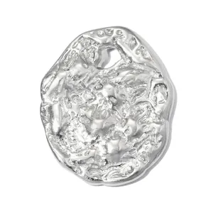 Detailed view of an irregular molten texture stainless steel coin pendant in silver tone