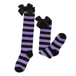 Detail of purple and black striped girl socks with large black satin bows