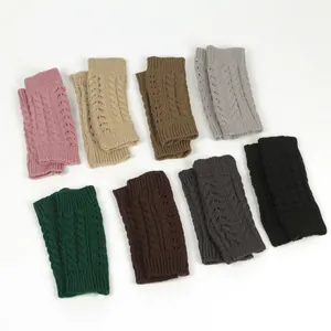Assorted cable-knit fingerless gloves in pink, beige, grey and other autumn colors.