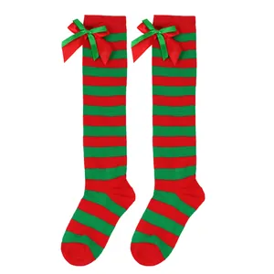 Close-up of red and green striped Christmas over-the-knee socks with satin bow details