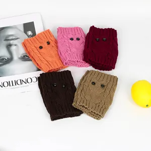 Macro view of colorful knitted owl-style boot cuffs with black bead eyes details.
