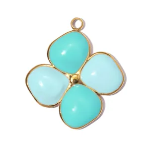 Detail of a gold-plated stainless steel four-leaf clover pendant with blue enamel.