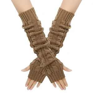 Detailopname van bruin kabelgebreid patroon op dikke warme vingerloze armwarmers.