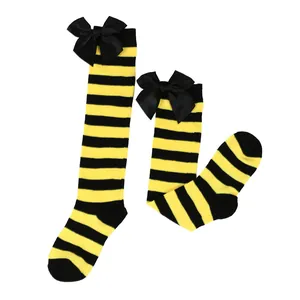 Detailed view of yellow and black striped girls' long socks with black bows for Halloween.